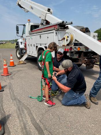 Kids had a chance to experience a day in the life of a co-op lineworker, trying on safety gear and riding in a bucket truck high above the event at Polk-Burnett Electric Cooperative in Centuria.